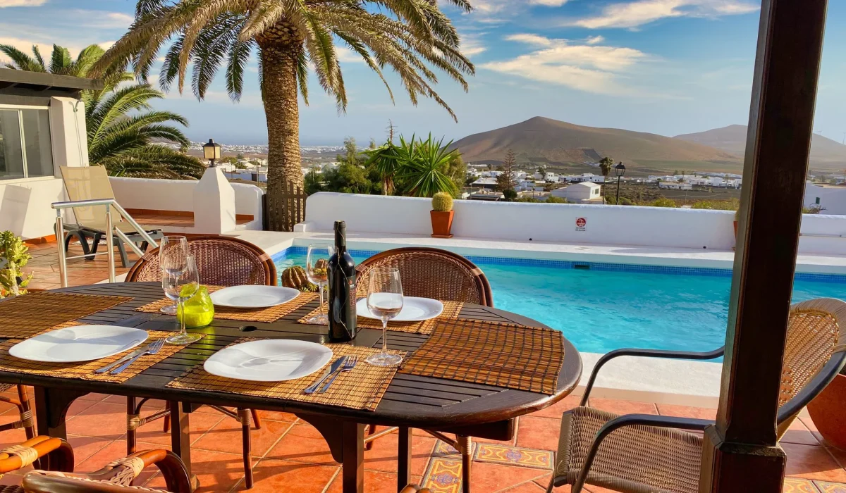 Table set on the terrace overlooking the pool and palm tree