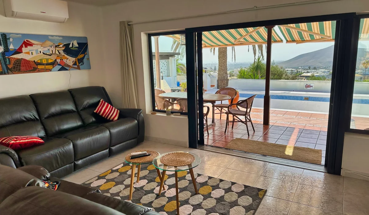 Living room with leather sofas and open sliding door to the terrace and pool